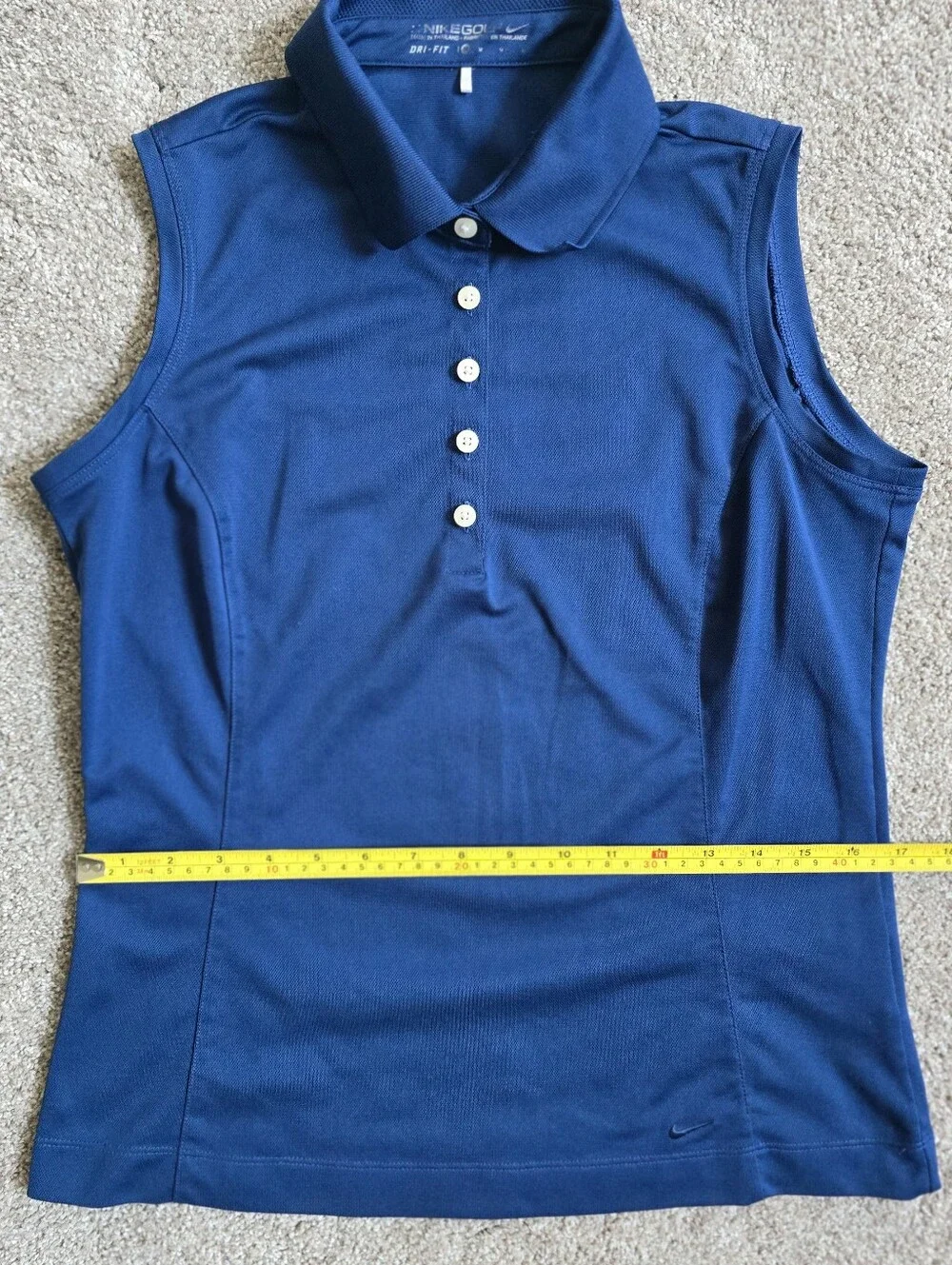 Royal blue sleeveless Nike Golf polo featuring a white-buttone